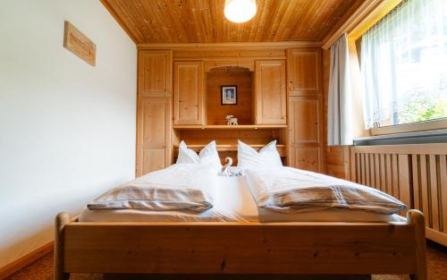 a bed with white sheets and pillows in a room at Garni Cir in Santa Cristina in Val Gardena