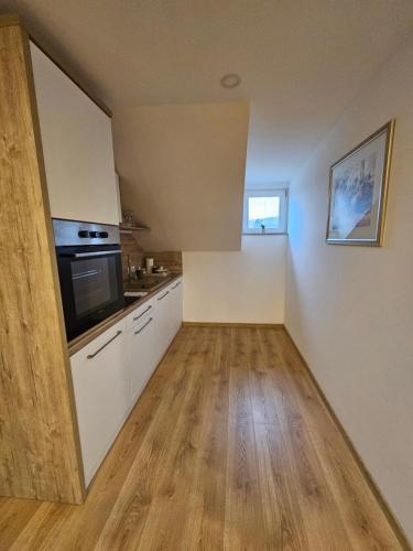 a kitchen with white cabinets and a black microwave at Apartmani Lotus Vrdnik in Vrdnik
