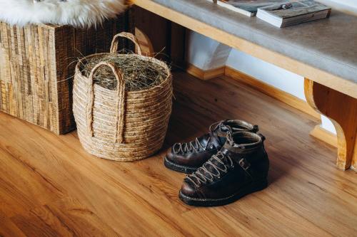 a pair of shoes and a basket on a wooden floor at Garni Cir in Santa Cristina in Val Gardena