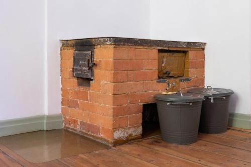 a brick fireplace with two trash cans in a room at Apartamenti Strand in Saulkrasti