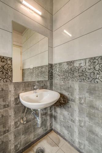 a bathroom with a sink and a mirror at Hotel J N Stay Mysore - 12 Minutes to Mysore Palace in Mysore