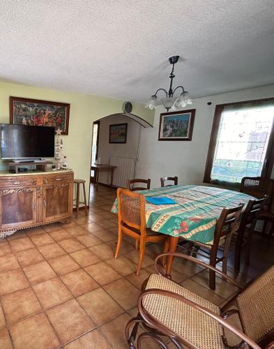une salle à manger avec une table et une télévision dans l'établissement Maison Savignac les ormeaux, à Savignac-les-Ormeaux