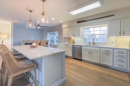 a kitchen with white cabinets and a large island at Dock Holiday in Sanibel