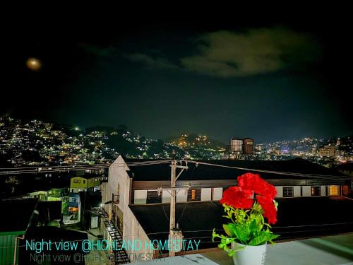 a red flower sitting on top of a building at night at Your Home near Burnham Park in Baguio