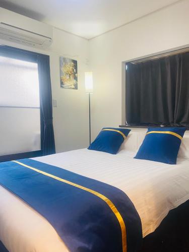 a bedroom with a large bed with blue pillows at Umeda Yodogawa Cozy Home A 步行到JR站5分钟 大阪梅田1站 新大阪2站 京都 神户直达 USJ地铁25分钟 in Osaka