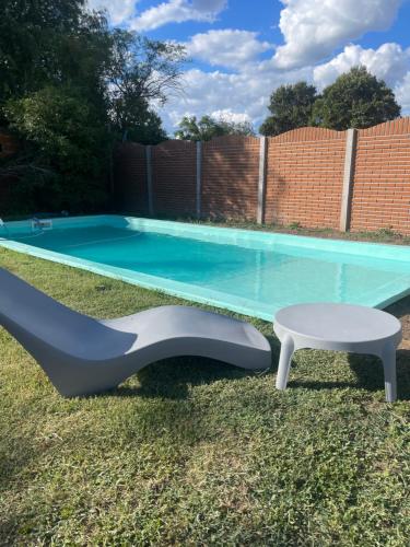 a pool table and a bench next to a swimming pool at hospedaje la familia in Villa Lía