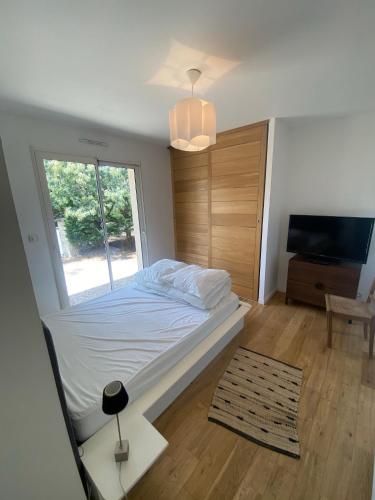 une chambre avec un grand lit et une fenêtre dans l'établissement VILLA LACANAU OCÉAN DANS LE GOLF, à Lacanau-Océan