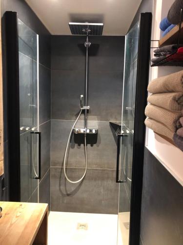 une douche avec une porte vitrée dans une salle de bain dans l'établissement Chalet Premium 10min Funiculaire Les Arcs, à Les Chapelles