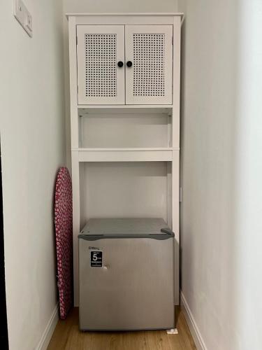 a white cabinet and a refrigerator in a room at Snuz by the Beach Kuantan in Kuantan