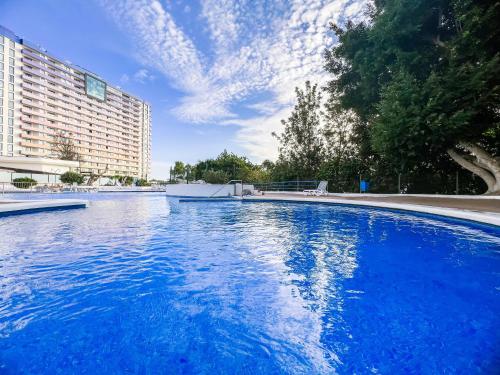 a large blue swimming pool in front of a building at Ocean Breeze 1 Bedroom Apartment, Mirador Paraiso PP18 in Playa Paraiso