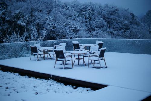a group of tables and chairs in the snow at Qingcheng Mount SuXi Qingshan Forest Hotel in Chongzhou