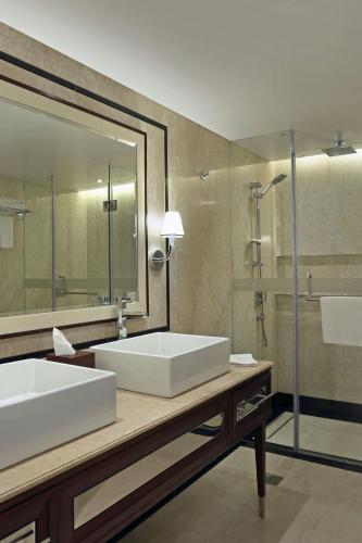 a bathroom with two sinks and a large mirror at Sheraton Grand Pune Bund Garden Hotel in Pune