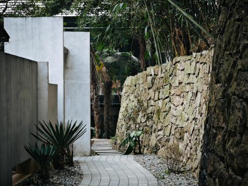 a stone wall next to a stone walkway at Qingcheng Mount SuXi Qingshan Forest Hotel in Chongzhou
