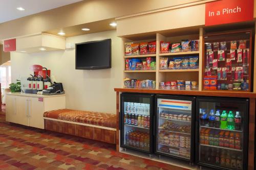 a grocery store with a shelf of drinks and a tv at TownePlace Suites Lubbock in Lubbock
