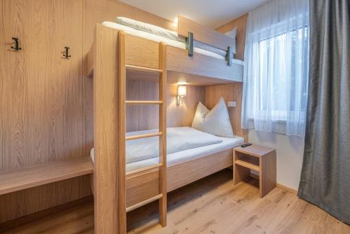 a small room with a bunk bed and a window at Apart Sonnenbichl in Sölden