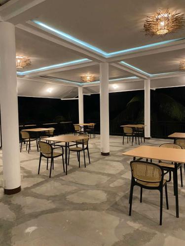 a row of tables and chairs in a room with lights at Ocam Ocam Casadyan Inn in New Busuanga
