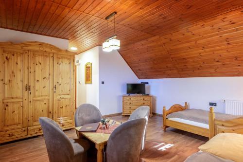 a living room with a bed and a table and chairs at Rezort u Bobiho in Nový Tekov