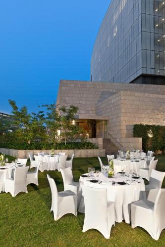 a group of white tables and chairs in front of a building at The Westin Gurgaon, New Delhi in Gurgaon