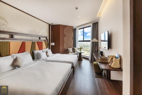 a hotel room with two beds and a window at Mandala Retreat Horizon Resort Mũi Né in Mui Ne