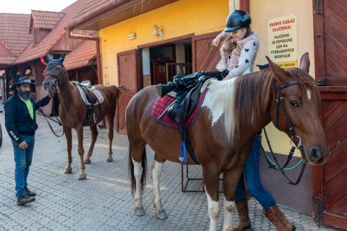 a young girl is sitting on a horse at Rezort u Bobiho in Nový Tekov