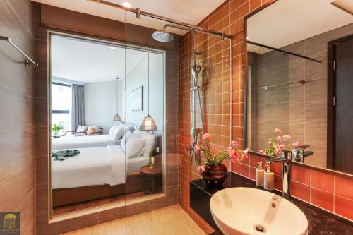 a bathroom with a sink and a bed and a mirror at Mandala Retreat Horizon Resort Mũi Né in Mui Ne
