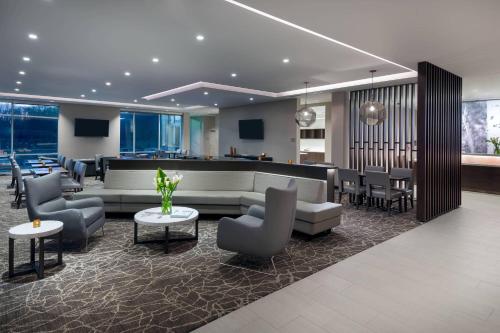 a lobby with a waiting area with chairs and tables at SpringHill Suites by Marriott Indianapolis Westfield in Westfield