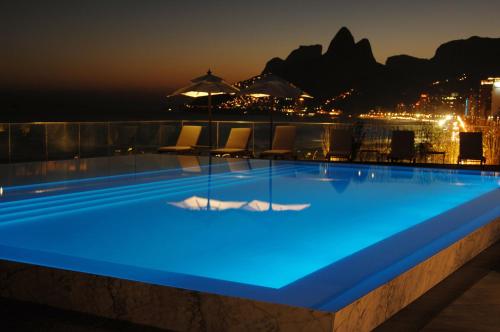 una piscina con iluminación azul en un edificio en TOP LEBLON Flats, en Río de Janeiro