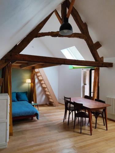 une pièce avec une table, des chaises et un lit dans l'établissement Agréable maisonnette en duplex, avec patio proche mer, à Lion-sur-Mer