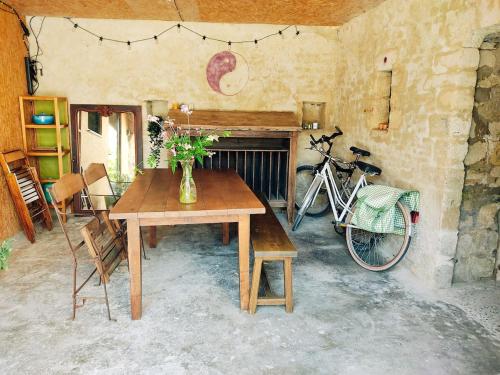 - une table et un vélo garés dans une chambre dans l'établissement Agréable maisonnette en duplex, avec patio proche mer, à Lion-sur-Mer