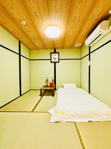 Habitación con cama y reloj en el techo en 大阪历史文化街区日式酒店 体验纯正和风生活 机场地铁直达, en Osaka