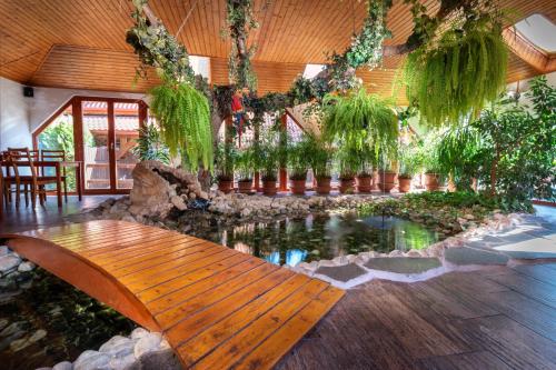 a room with a fish pond and a wooden bench at Rezort u Bobiho in Nový Tekov