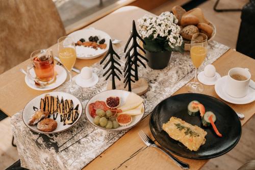 a table topped with plates of food and drinks at Feuriger Tatzlwurm Berghotel & Spa, BW Signature Collection in Oberaudorf