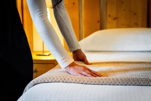 a person is making a bed with a blanket at Agriturismo La Fiorida in Mantello