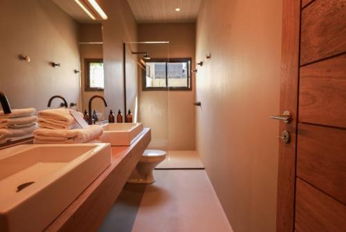 a bathroom with two sinks and a toilet at Barracuda Boutique in Itacaré