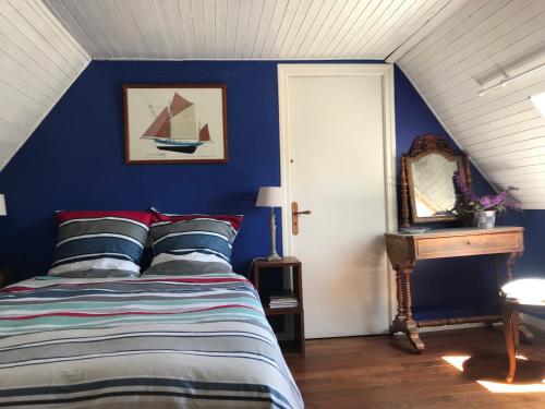 a blue bedroom with a bed and a mirror at Chambres d'Hôtes Maison de Charme à Trégastel in Trégastel