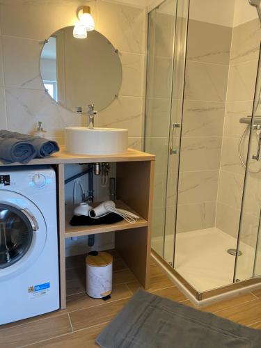 une salle de bain avec un lavabo et une machine à laver dans l'établissement T2, Jardinet, Quartier marché 10mn Plage, à Royan