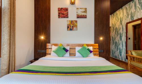 a bedroom with a large bed with green pillows at Treebo Vista Lago With Lake View in Bhīm Tāl