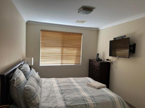 a bedroom with a bed and a window and a television at Country Oasis on Evans Street in Collie