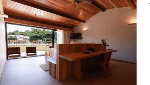 a bedroom with a desk and a bed and a bed and a window at Barracuda Boutique in Itacaré