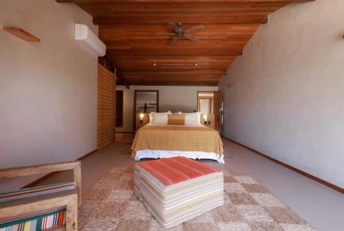a bedroom with a bed and a wooden ceiling at Barracuda Boutique in Itacaré