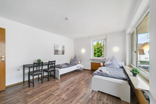 a bedroom with a bed and a desk and a table at Monteurwohnungen in Göppingen 04-07 in Göppingen