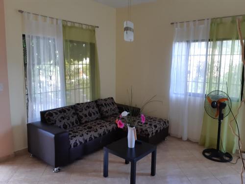 a living room with a black couch and a table at Caleton Group in Río San Juan