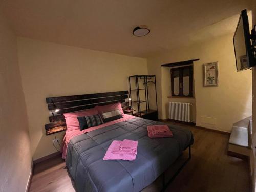 a bedroom with a large bed with pink towels on it at La ferruccina, terratetto a 2 passi dalla piazza in Gavinana