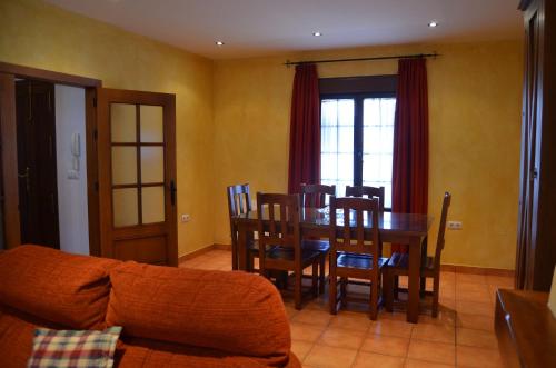 sala de estar con mesa, sillas y sofá en Casa Miguel - El Bosque, en El Bosque