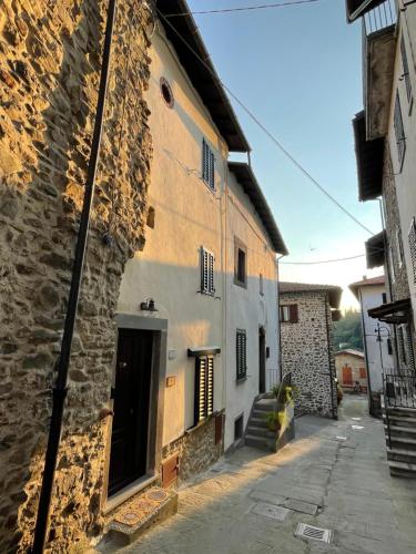 an old stone building with a door and a stairway at La ferruccina, terratetto a 2 passi dalla piazza in Gavinana