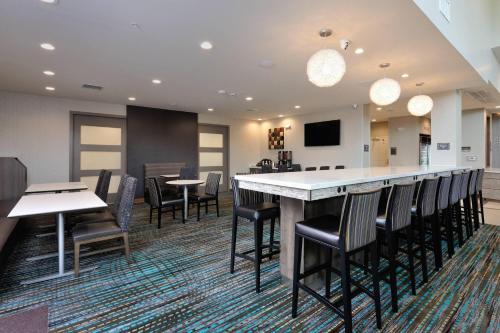a lobby with a bar with chairs and tables at Residence Inn by Marriott Houston Tomball in Tomball