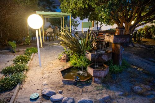 a garden with a water fountain and a street light at Hotel Prinzessin Rupprecht in Swakopmund