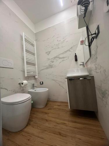 a white bathroom with a toilet and a sink at B&B La Quarantola in Pisa