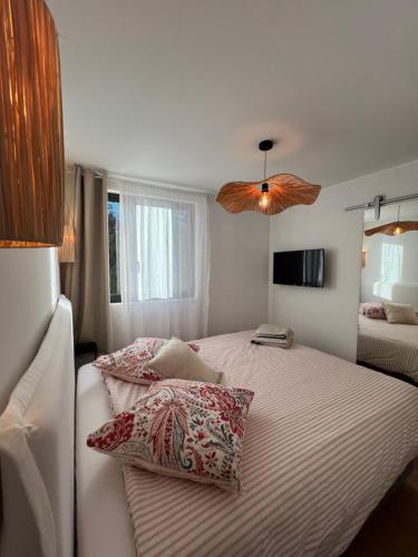 une chambre avec un grand lit avec des oreillers dessus dans l'établissement La Corniche - vue mer à 180 degrés - centre ville, à Bandol