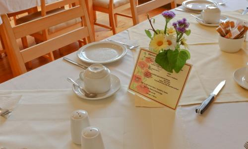 a table with a white table cloth with flowers on it at Hotel Prinzessin Rupprecht in Swakopmund